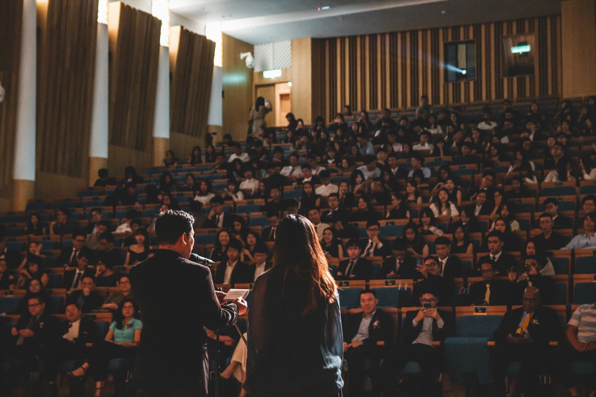 Hai diễn giả trình bày trước hội trường đông kín tại một hội thảo quốc tế